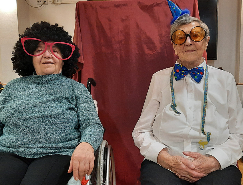 Zwei mit Hüten und Brillen verkleidete Bewohnerinnen