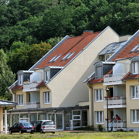 Standort avendi mobil Weißenfels, gelbes Gebäude über Wiese fotografiert, zwei Autos stehen vor dem Haus.